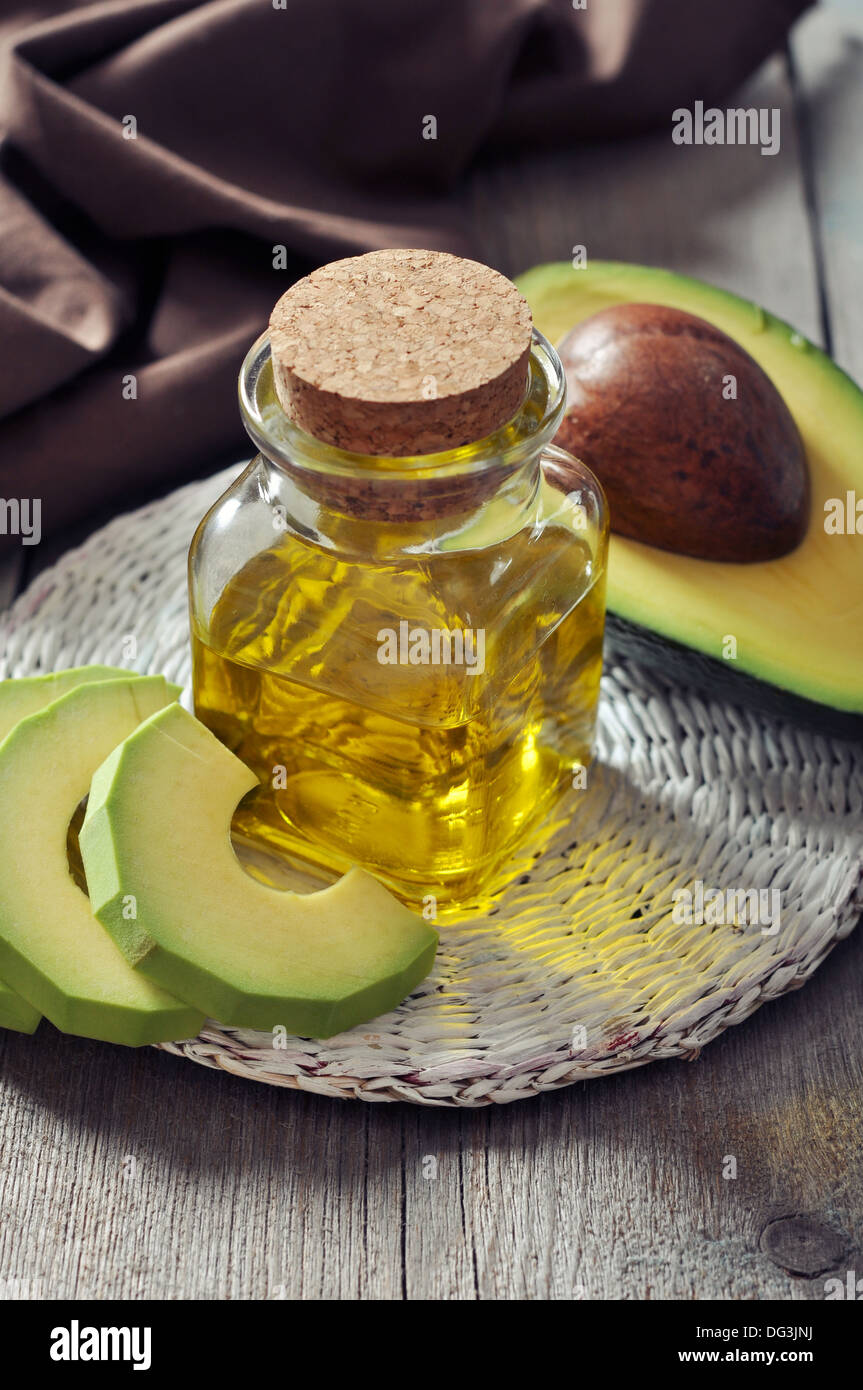 Bottiglia di avocado olio essenziale con fresca frutta avocado closeup Foto Stock
