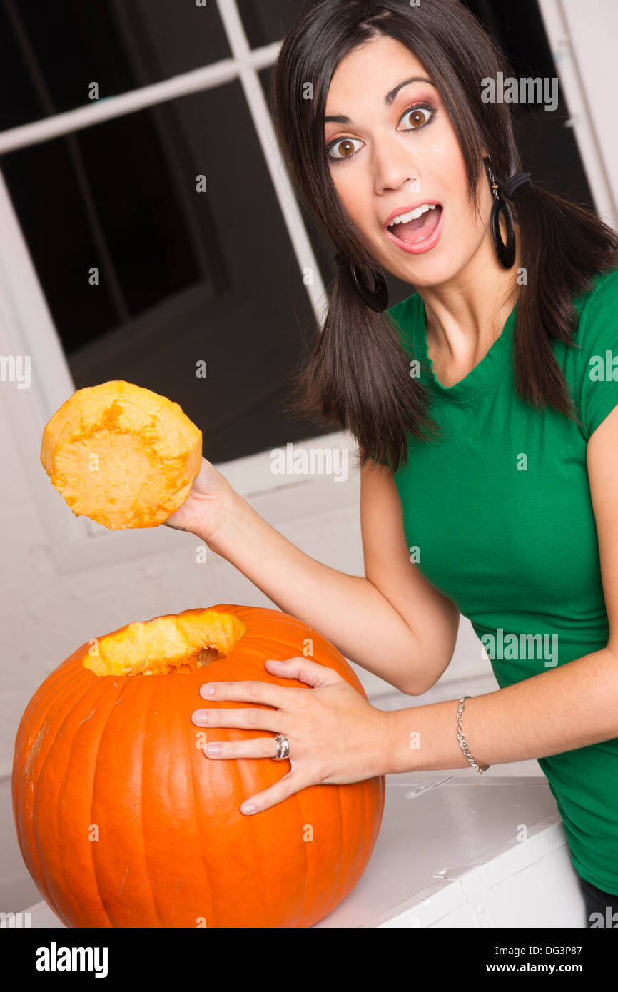 Piuttosto casalinga che taglia la parte superiore di una zucca di averlo pronto per scolpire Foto Stock