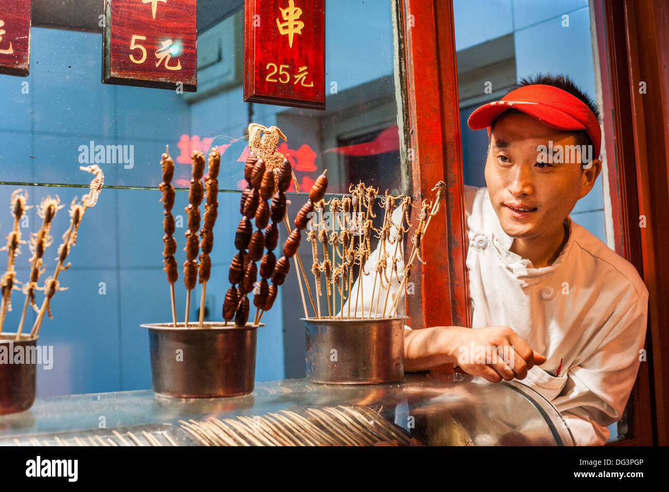 Venditore a vendere i cavallucci marini e coleotteri su un bastone, il Mercato Notturno Wangfujing di Pechino, Cina, Asia Foto Stock