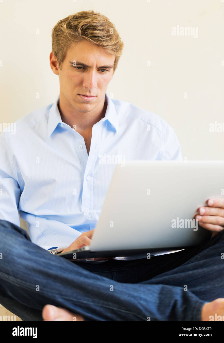 Attraente giovane uomo che lavora sul computer portatile a casa Foto Stock