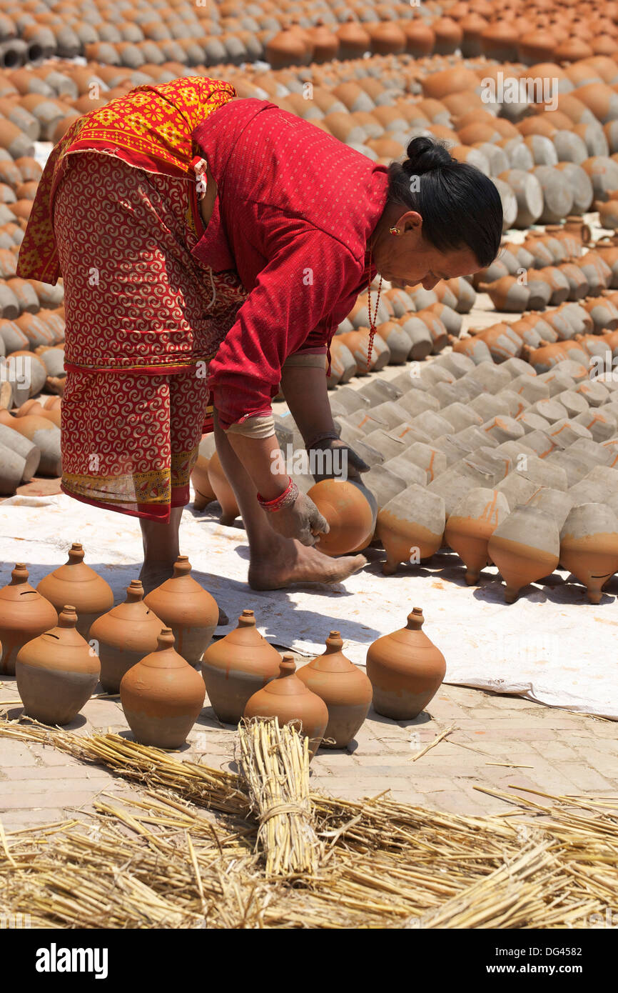 Donna pentole di tornitura ad asciugare al sole, Potter's Square, Bhaktapur, Nepal, Asia Foto Stock