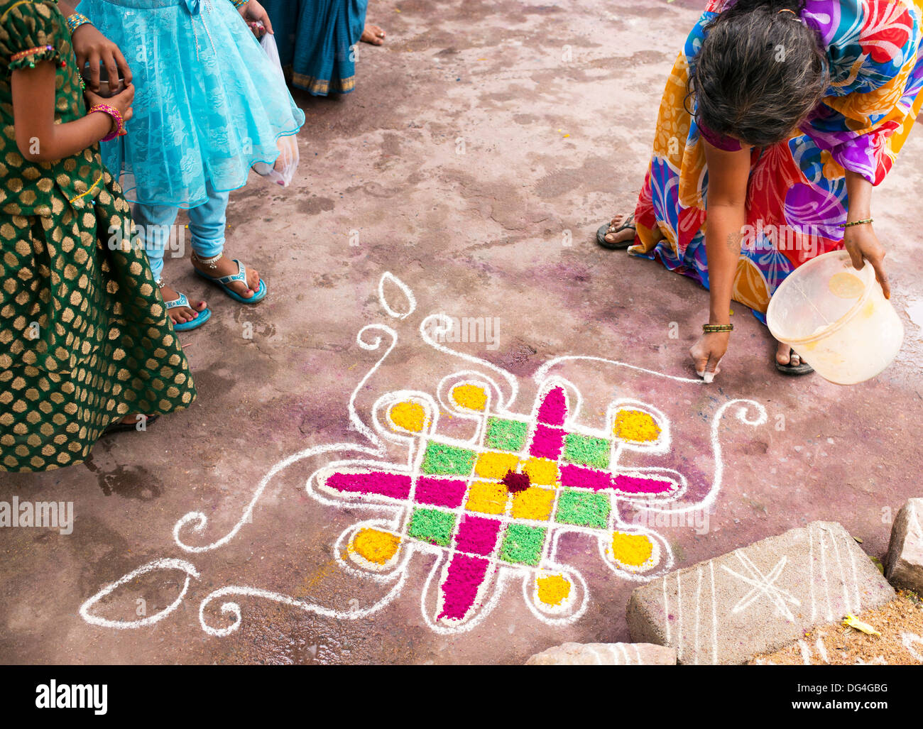 Donna indiana rendendo Dasara Rangoli festival di polvere colorata design. Puttaparthi, Andhra Pradesh, India Foto Stock