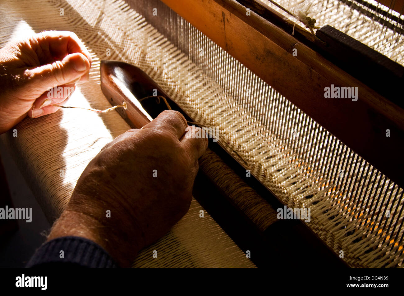 Tessitura tradizionale in Eddie Doherty il tweed workshop a Ardara County Donegal Irlanda. Qui Eddie thread una navetta Foto Stock