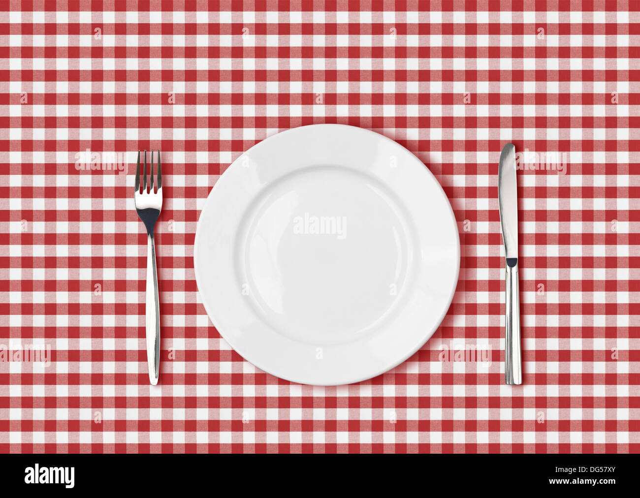 Coltello, piastra bianca e la forcella sulla rossa picnic panno della tabella Foto Stock