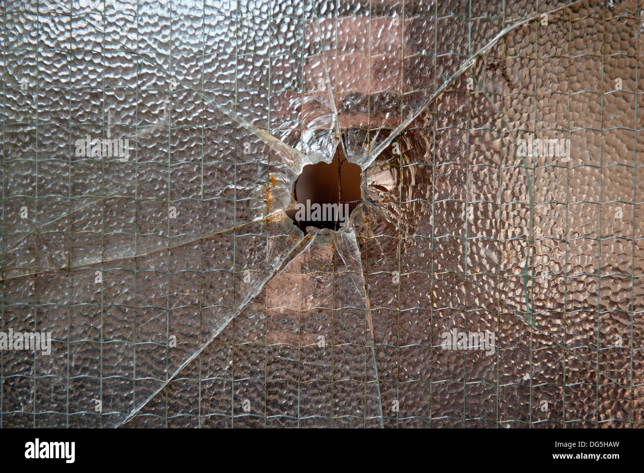 Un foro sui tome vetro temperato che potrebbe essere stato causato da un proiettile sparato da un cannone Foto Stock