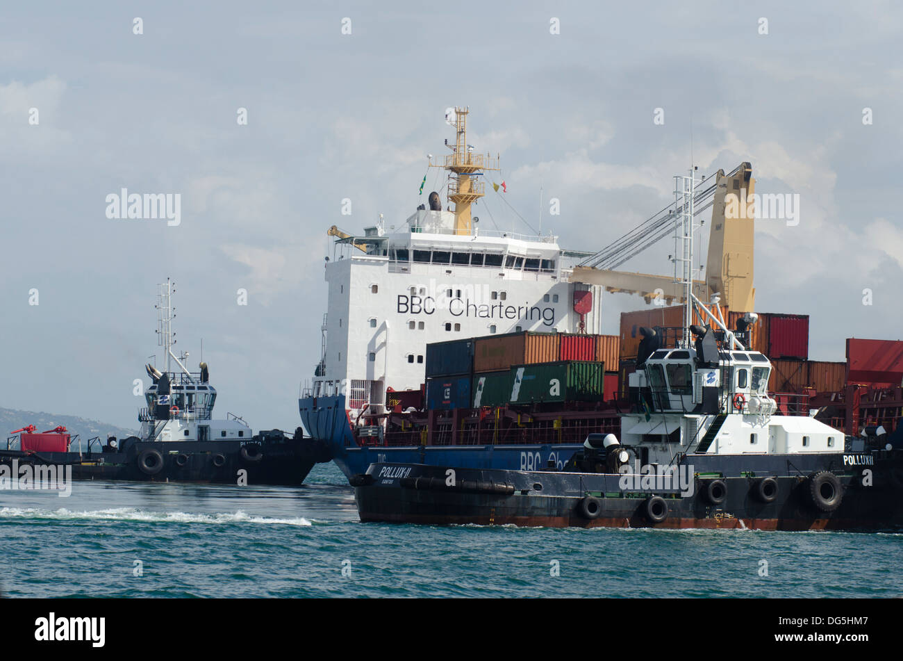 Barche rimorchiatore aiutando una nave da carico per interrompere a Sao Sebastiao porta, Sao Paulo membro a riva, Brasile Foto Stock
