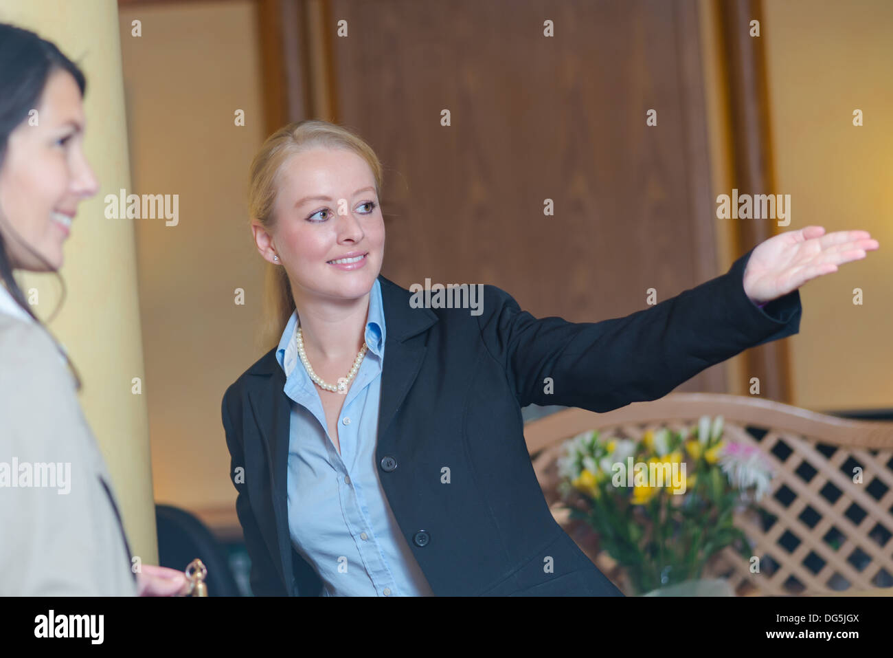 Receptionist in hotel aiutando gli ospiti di sesso femminile Foto Stock