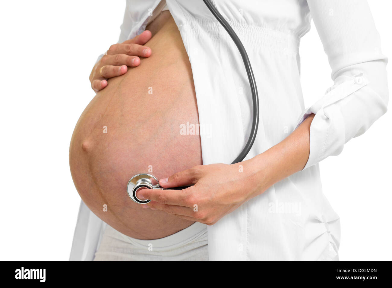 Donna incinta ascoltando il suo stomaco con uno stetoscopio Foto Stock