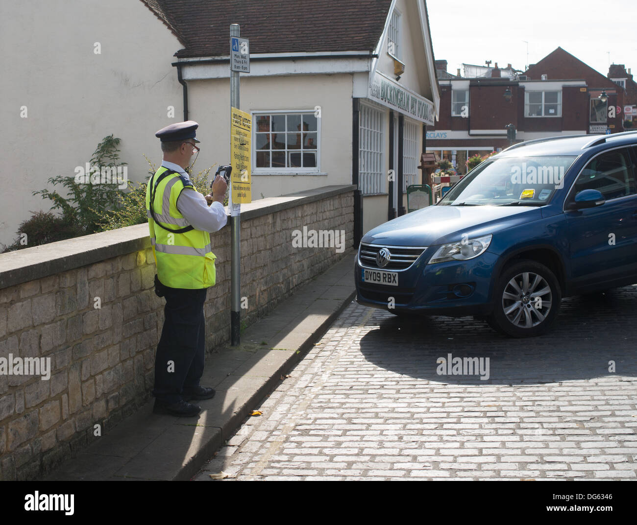 Vigile registra i dettagli del ticketed auto in Buckingham, England, Regno Unito Foto Stock