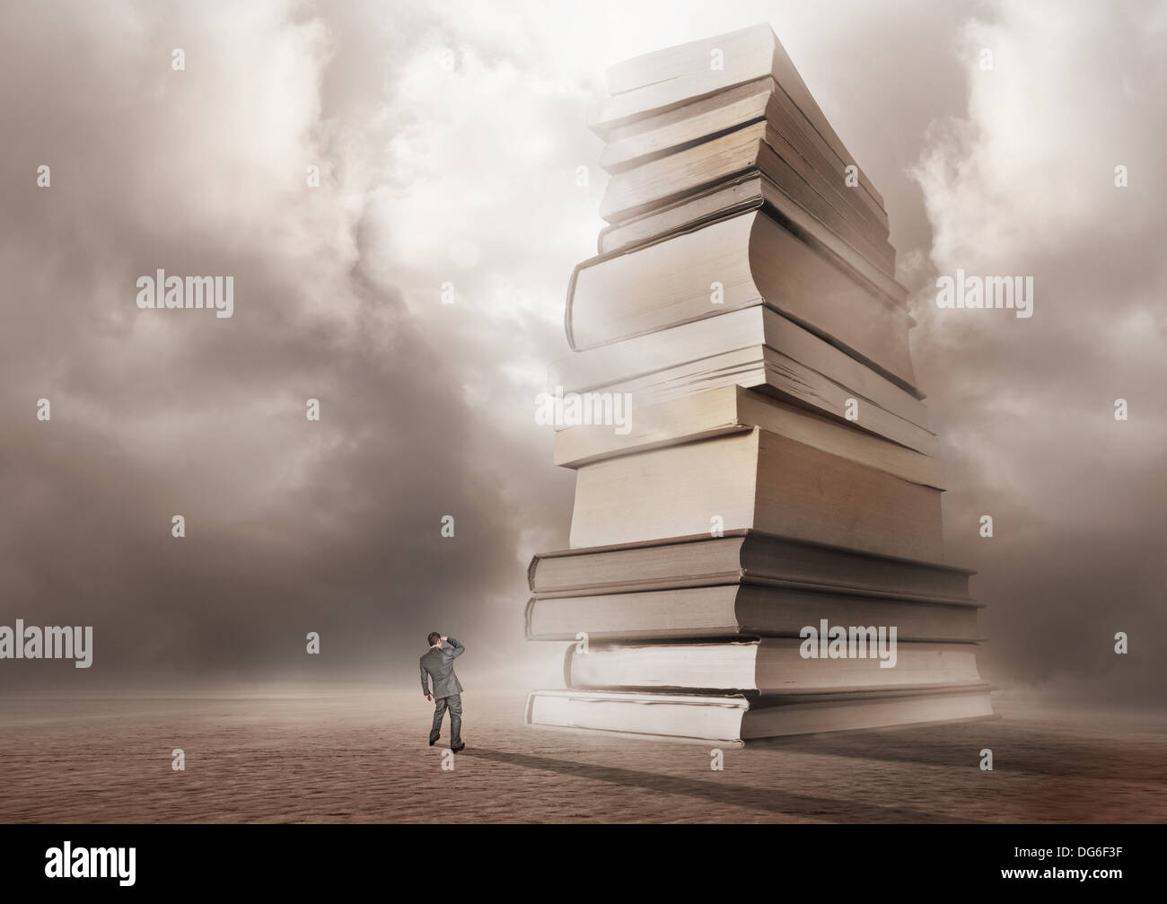 Un uomo guarda in avanti una montagna di libri. Foto Stock