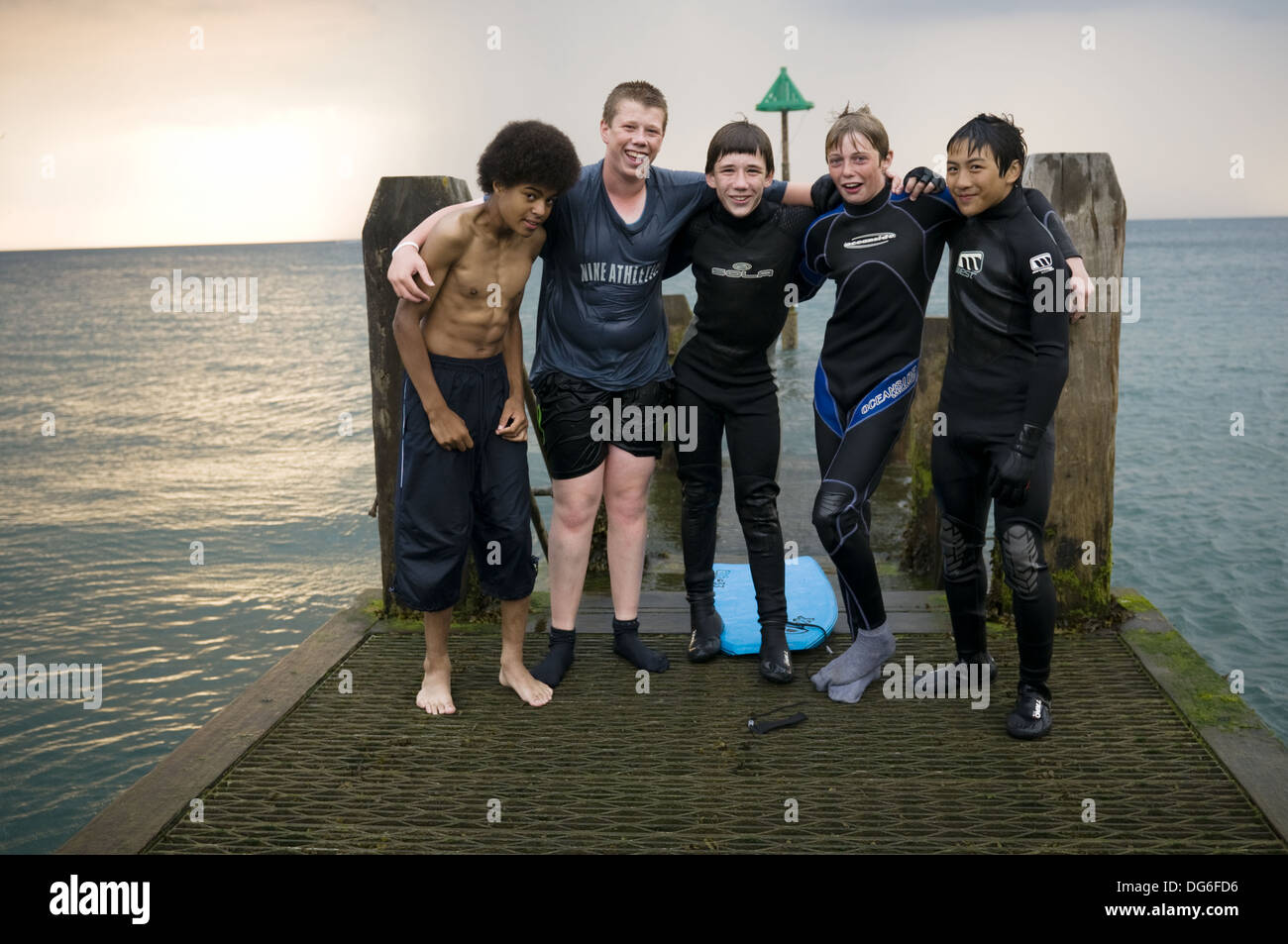 Inter - gruppo razziale di cinque ragazzi adolescenti, cinese nero e  bianco, in piedi sul jetty pier, serata estiva, indossando vestiti bagnati  Foto stock - Alamy