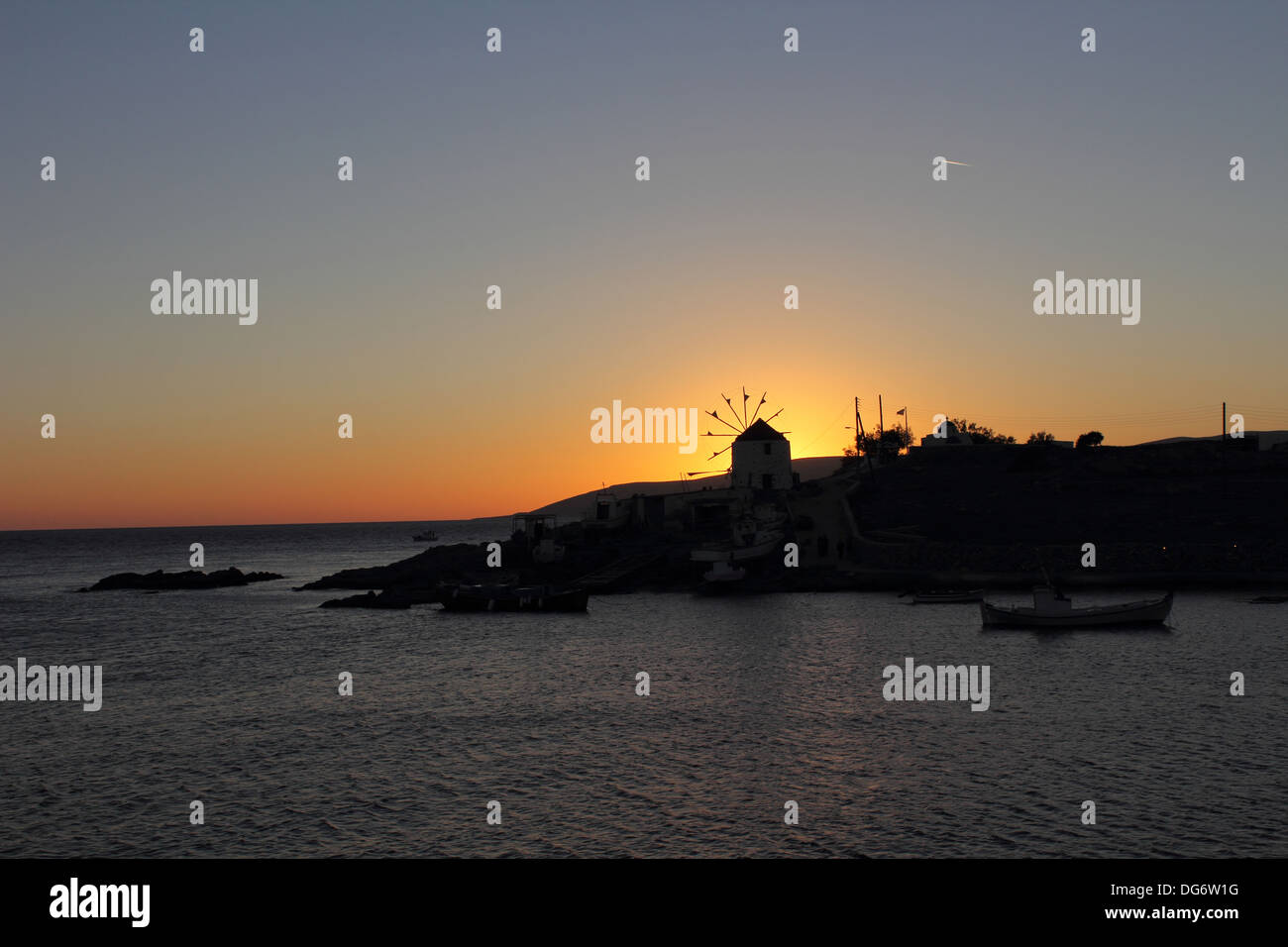 Tramonto dietro il mulino a vento Foto Stock