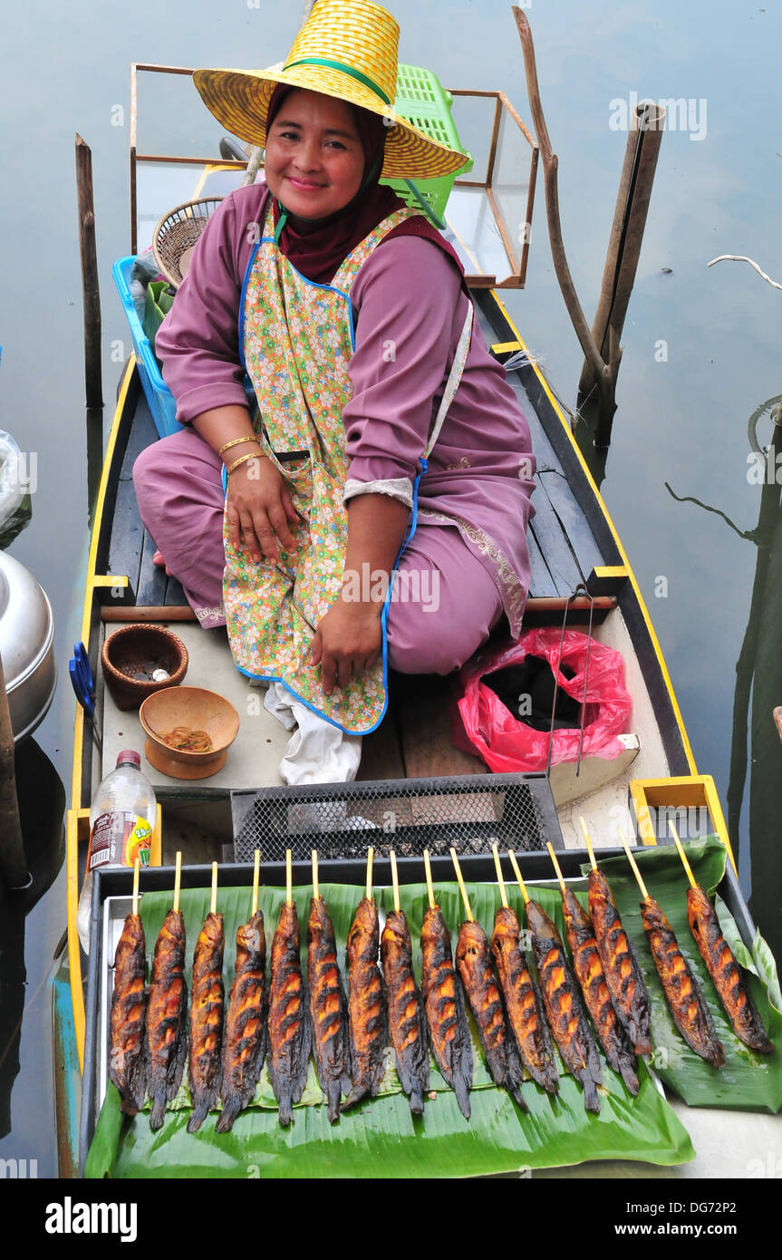 Un musulmano Thai lady vendita di grigliate di pesce gatto al di Hatyai Klong Hae Mercato galleggiante nel sud della Thailandia Foto Stock