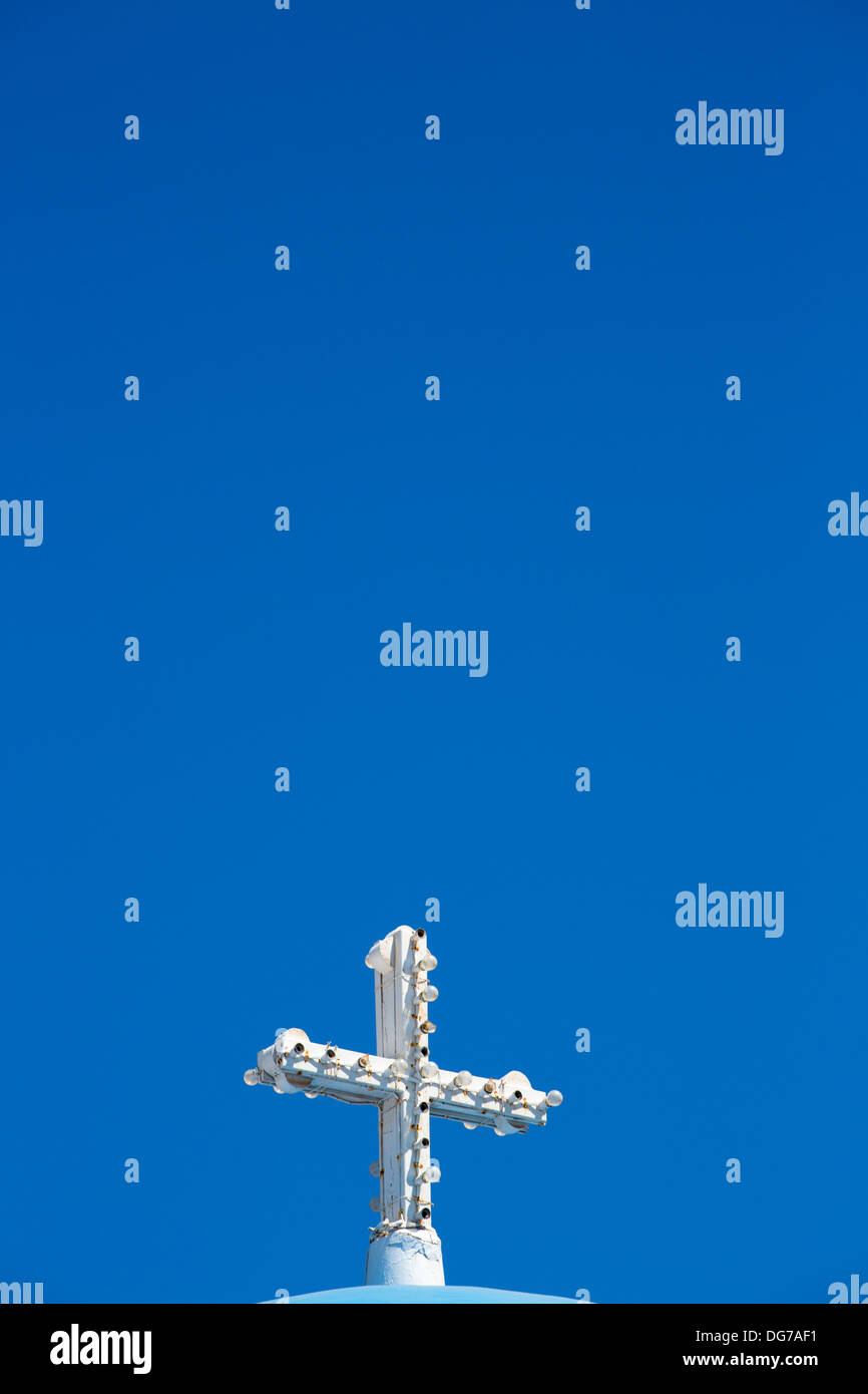 Croce ortodossa con lampadine. Ci sono molte piccole chiese in tutta Santorini. Foto Stock