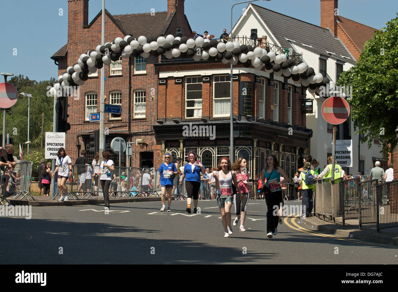 I corridori attraversano il traguardo sul grande Midlands Fun Run passa attraverso Sutton Coldfield, West Midlands. Foto Stock