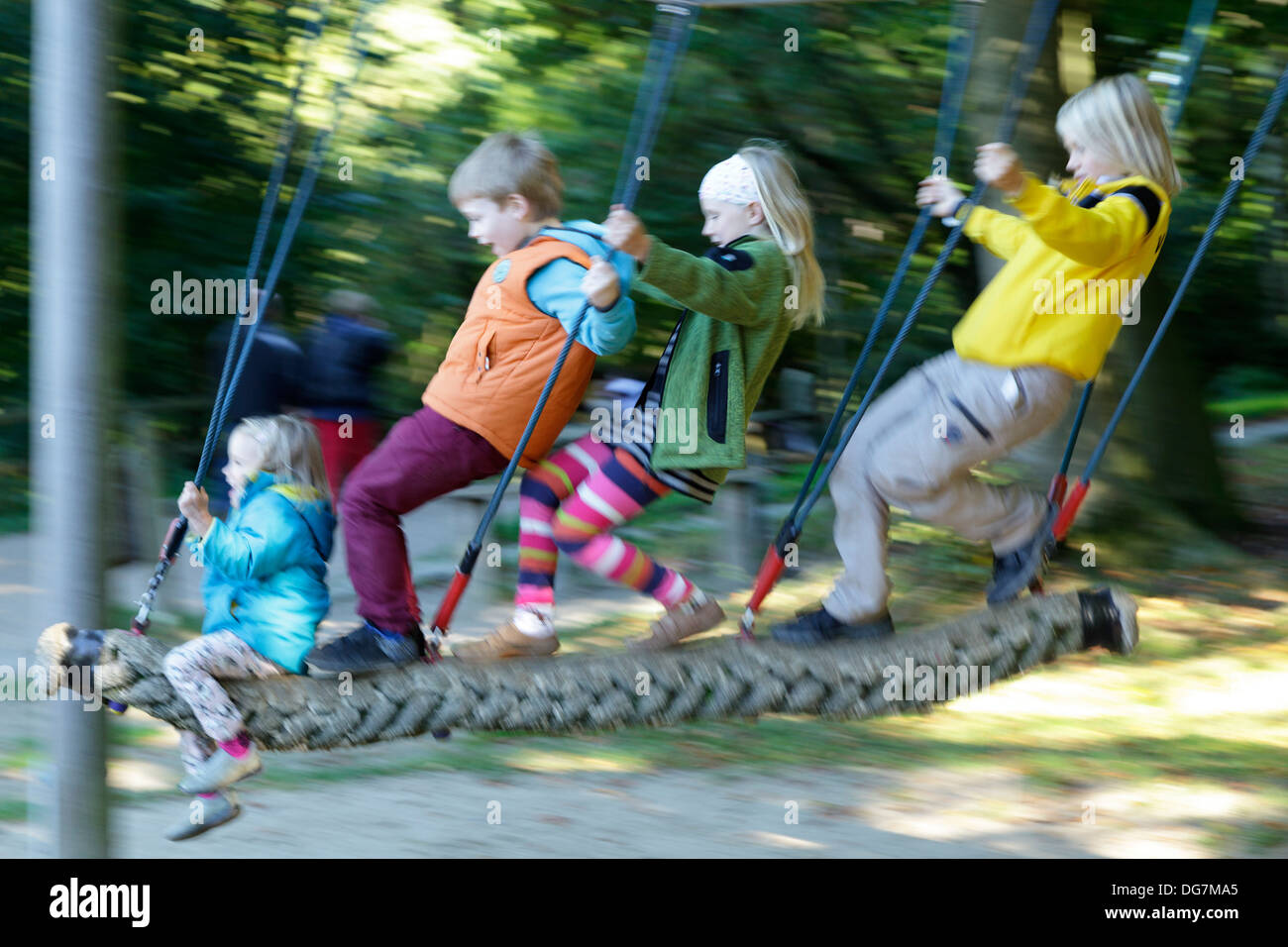 Quattro bambini su uno swing Foto Stock