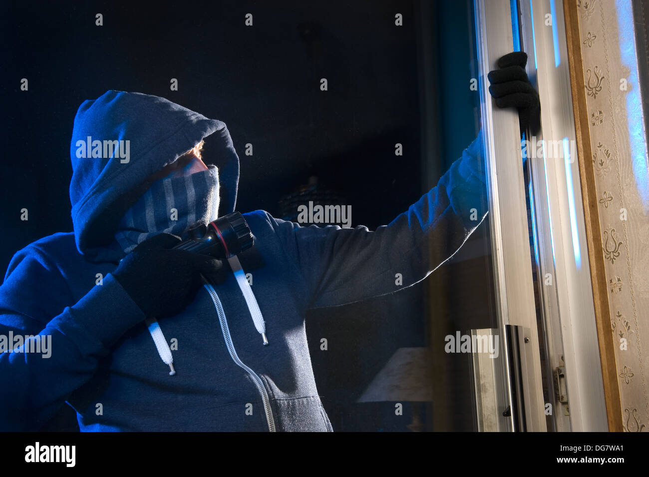 Un ladro sta cercando di entrare in una casa dalla porta posteriore Foto Stock