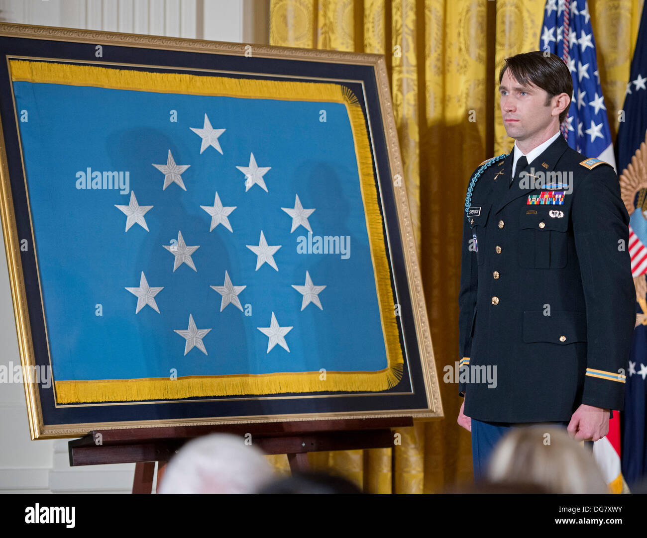 William Swenson, un ex active duty esercito capitano, che saranno premiati con la medaglia d'Onore per la cospicua galanteria, ascolta come presidente degli Stati Uniti Barack Obama fa commento nella Sala Est della Casa Bianca di Washington il 14 ottobre 2013. Capitano Swenson ha accettato la medaglia d'onore per le sue azioni coraggiose mentre serve come un Trainer incorporato e la guida delle forze di sicurezza nazionali afgane con la frontiera afgana di polizia team Mentor, 1° Battaglione, XXXII Reggimento di Fanteria, 3° Brigata Team di combattimento, decimo Montagna divisione, durante le operazioni di combattimento in provincia Kunar, Afghanistan su Foto Stock