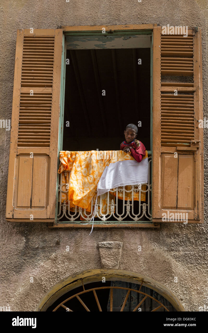Il Senegal, Saint Louis. Ragazzo nella finestra . Foto Stock