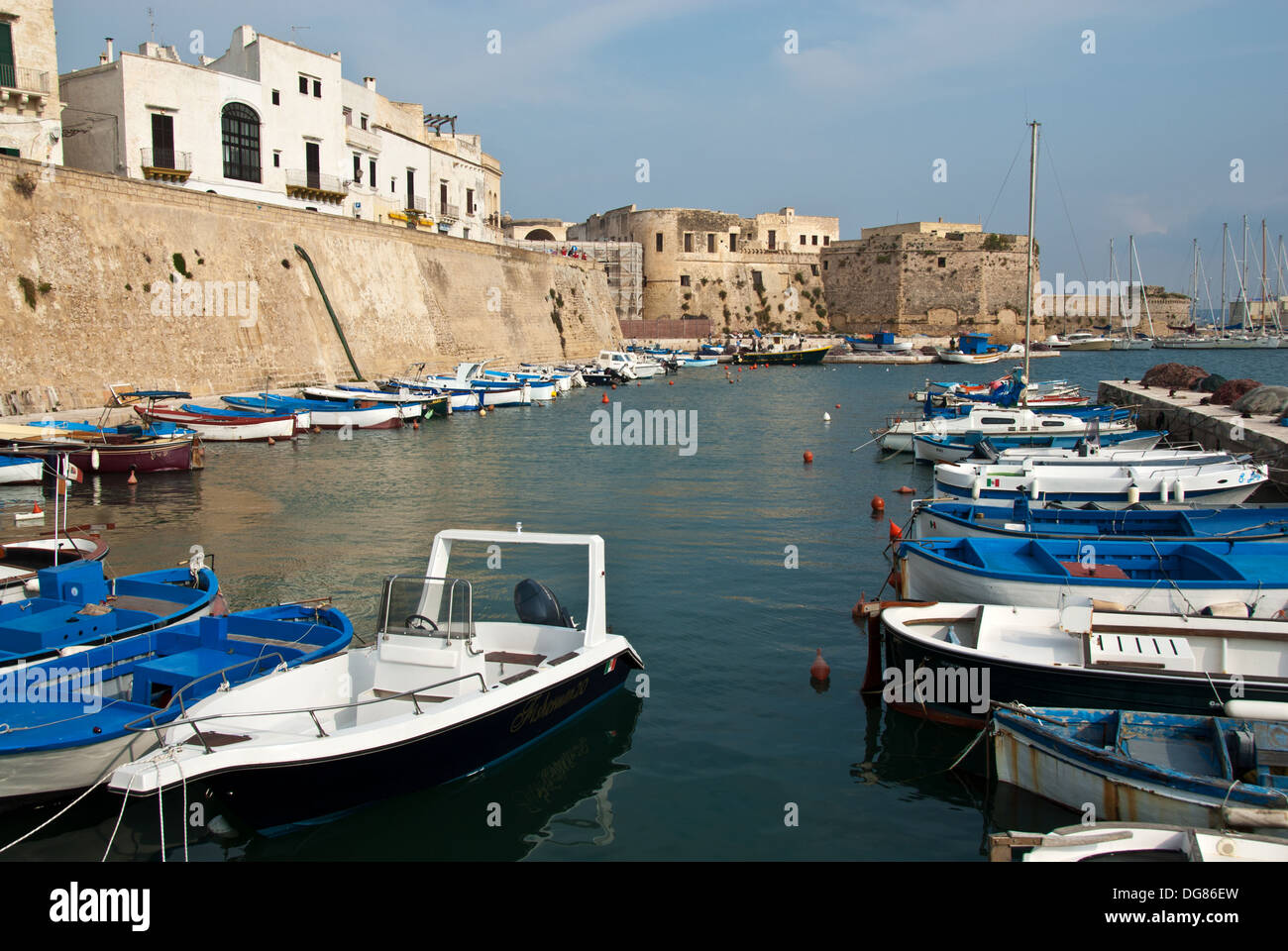 Gallipoli Puglia, mura medievali della città e barche da pesca in porto, Italia Foto Stock