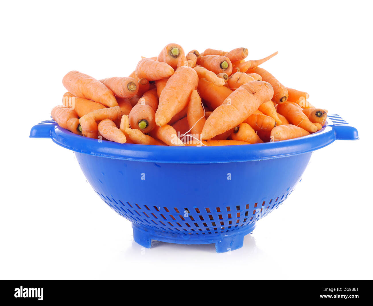 Mazzo di carote fresche in plastica blu scolapasta shot su bianco Foto Stock