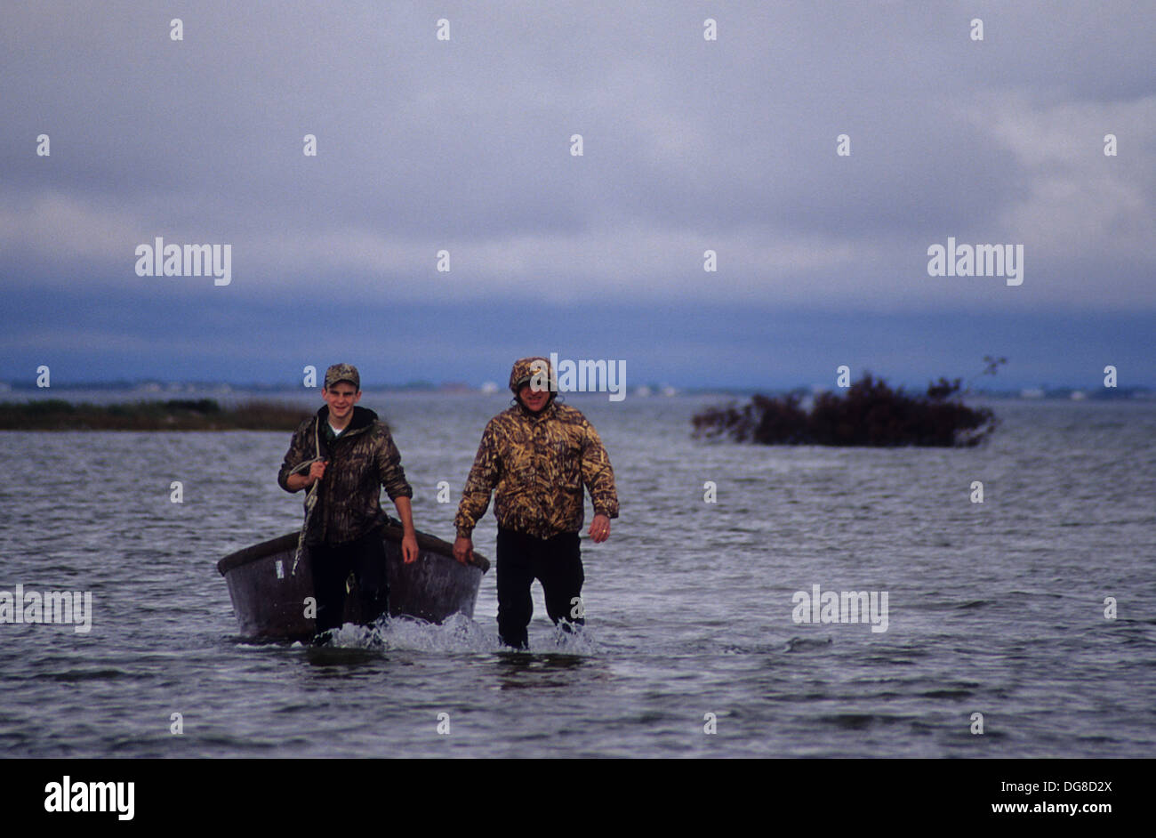 Cacciatori di anatre trascinando il loro legno attraverso la baia vicino a Rockport Texas Foto Stock