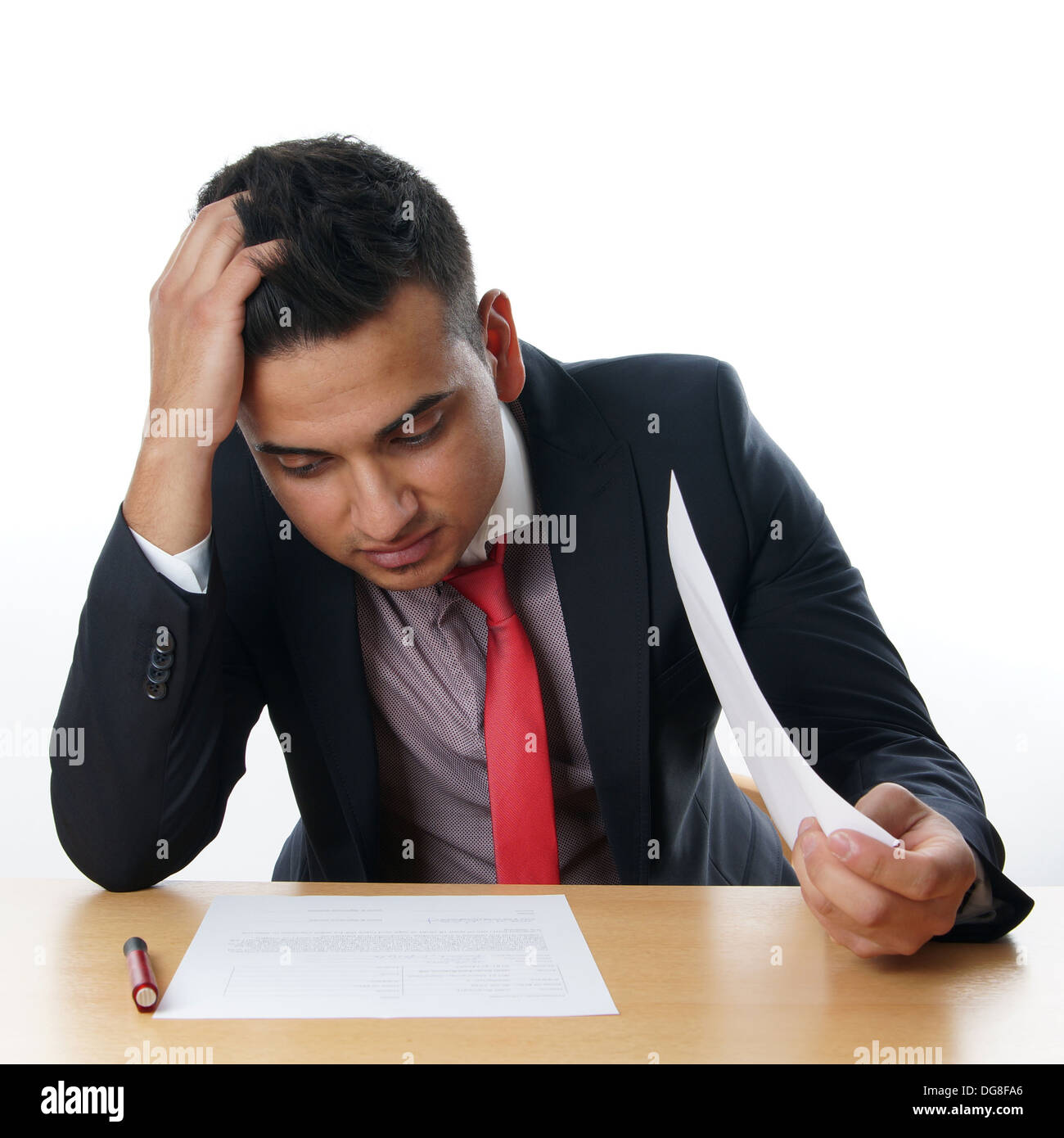 L'uomo leggendo il contratto alla sua scrivania Foto Stock