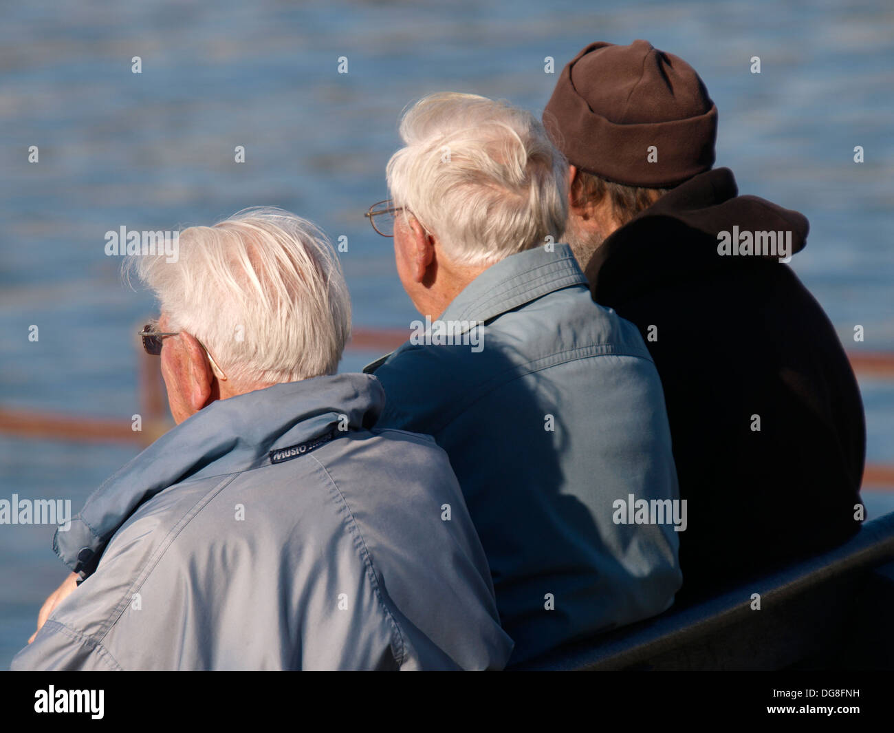 Tre uomini anziani seduti su una panchina, Bude, Cornwall, Regno Unito Foto Stock