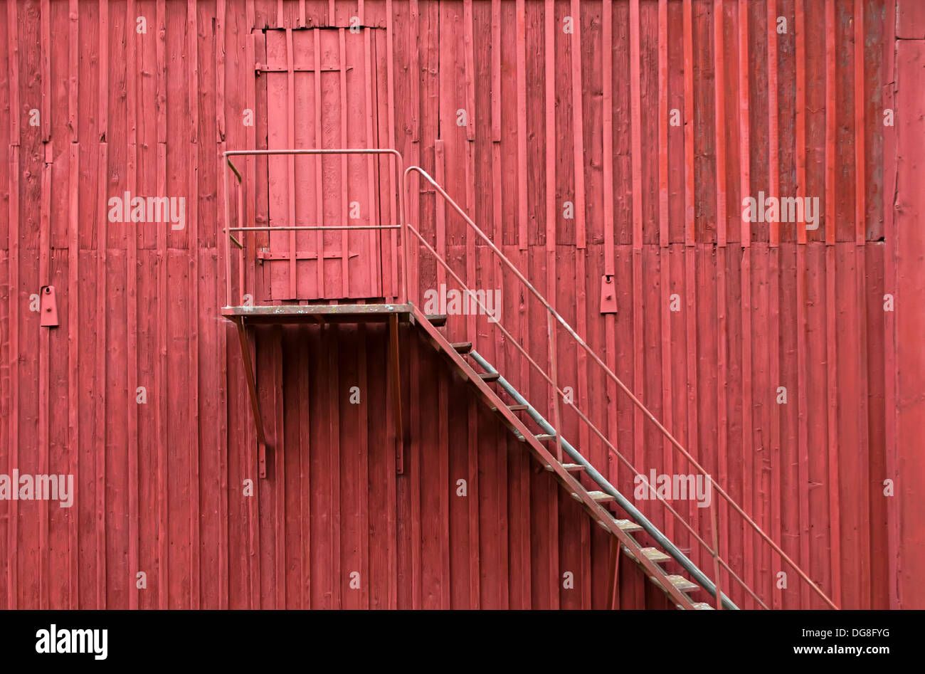 La scala e il retro della porta d'ingresso sul rosso parete in legno Foto Stock