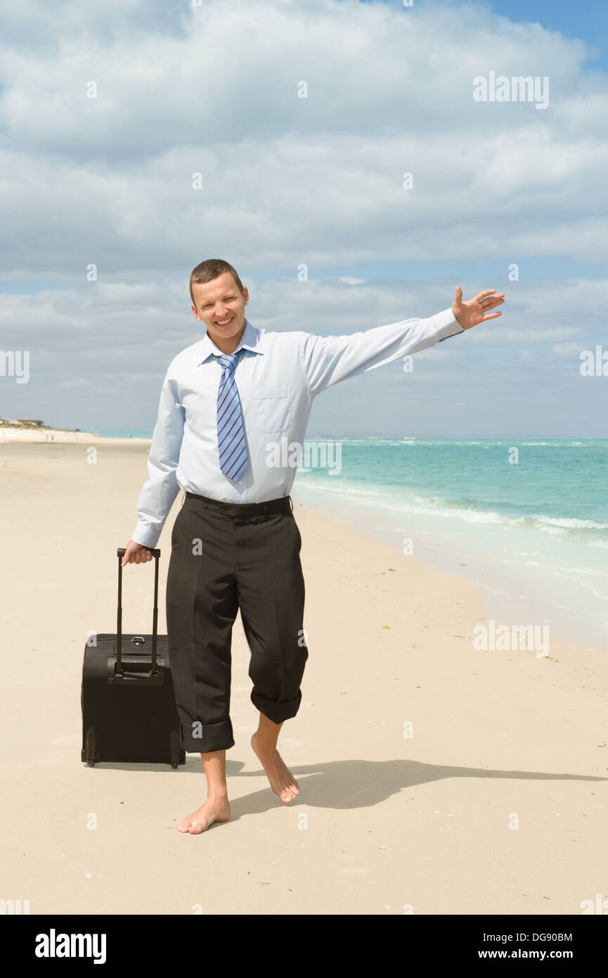 Imprenditore di camminare sulla spiaggia il primo giorno di vacanza Foto Stock