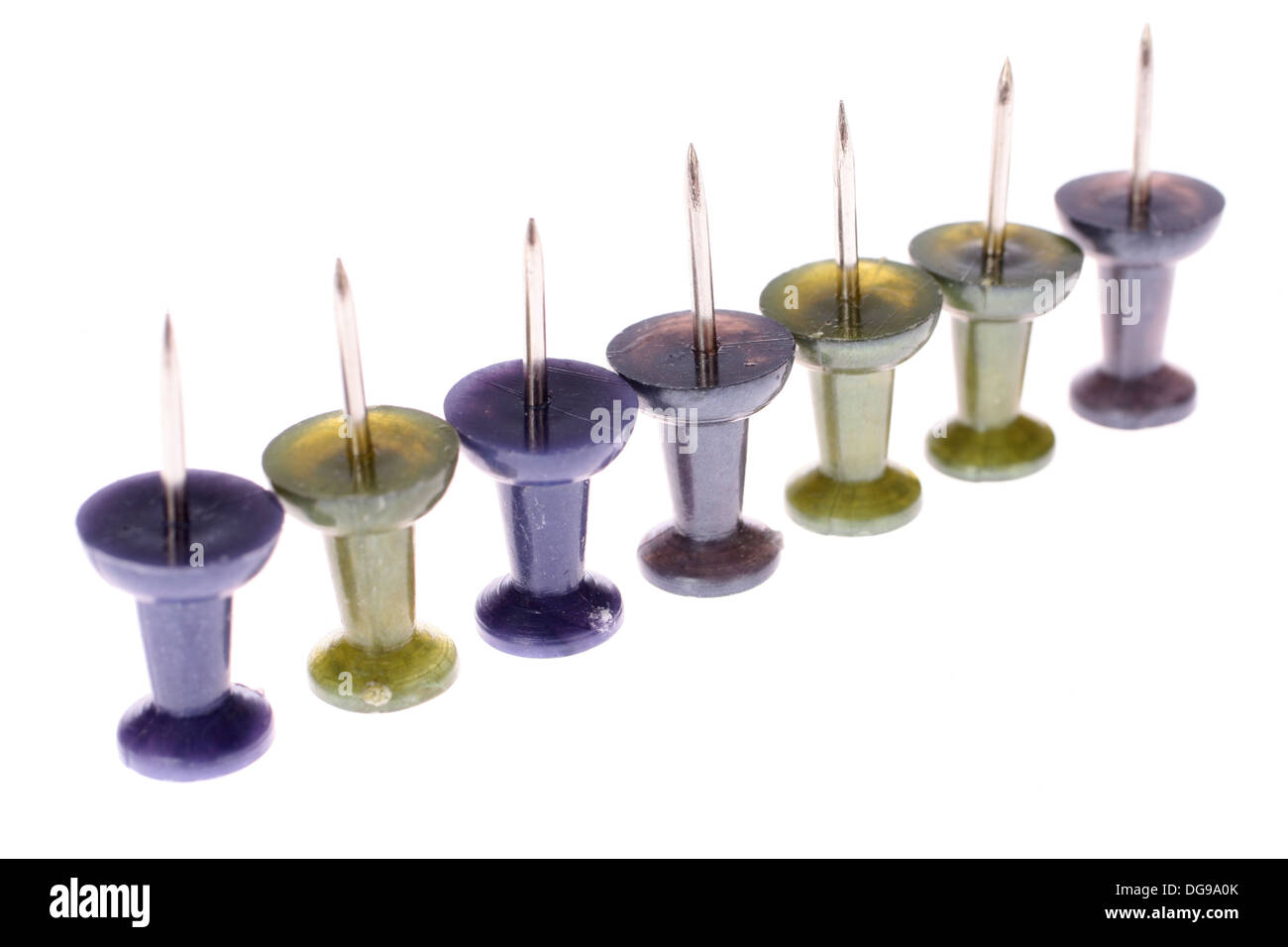 Una fila di vivacemente colorato pollice chiodini o puntine da disegno Foto Stock