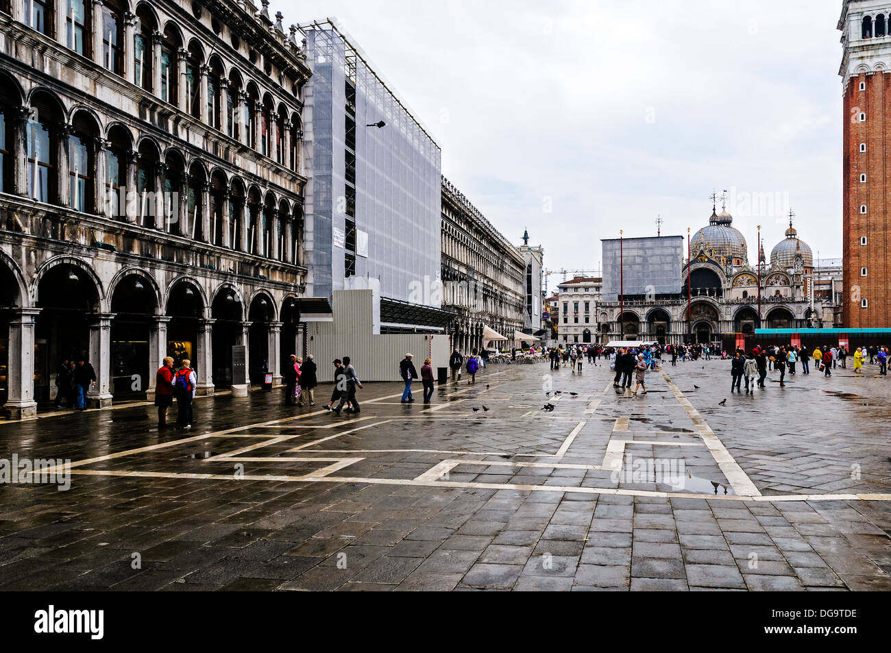 La folla di turisti a piedi su Piazza San Marco ammirando le facciate eleganti e riccamente decorati di mosaici della Basilica, Venezia Foto Stock