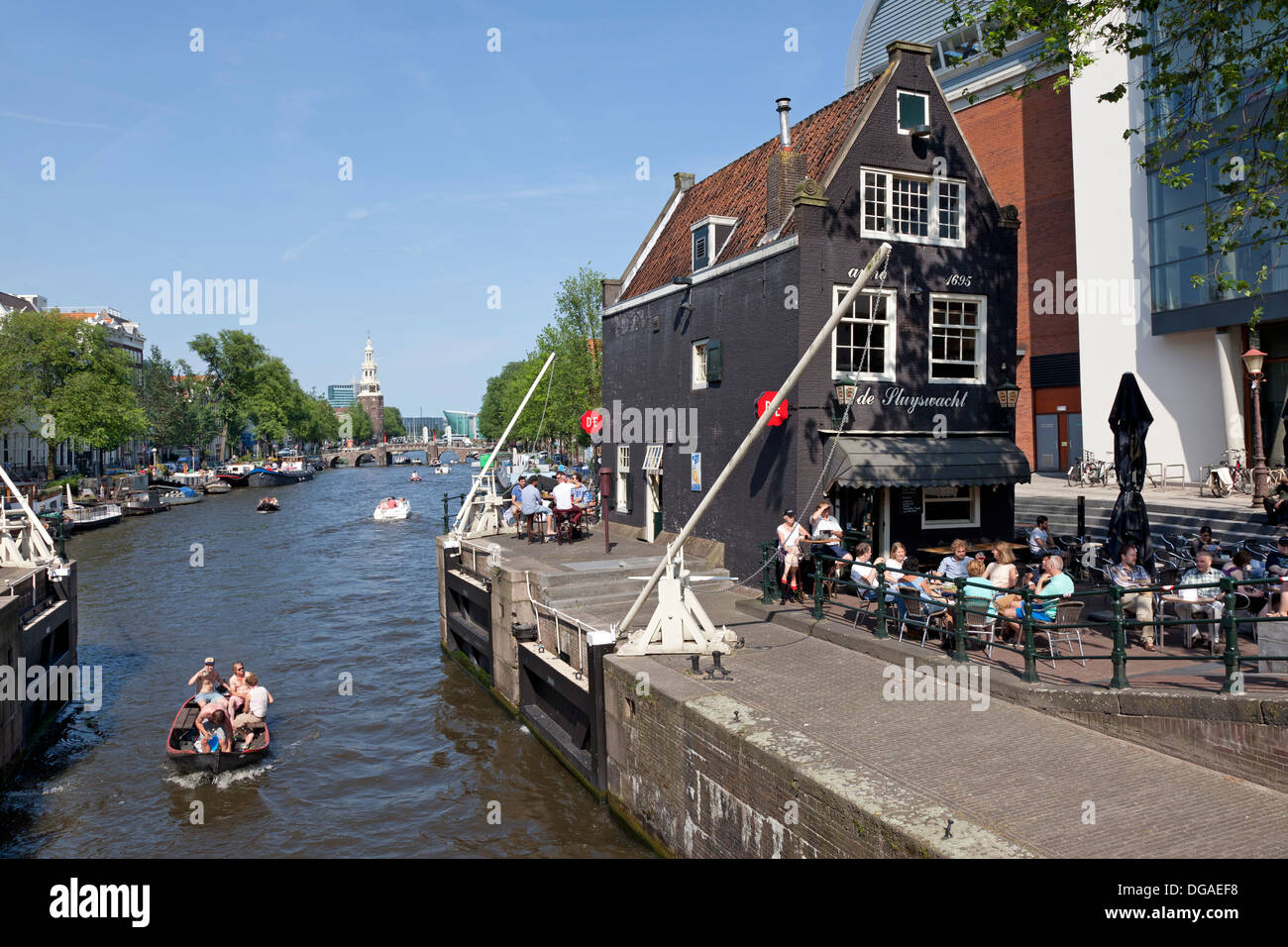 Bloccare nel canale di Amsterdam con sullo sfondo la torre Montelbaans Foto Stock