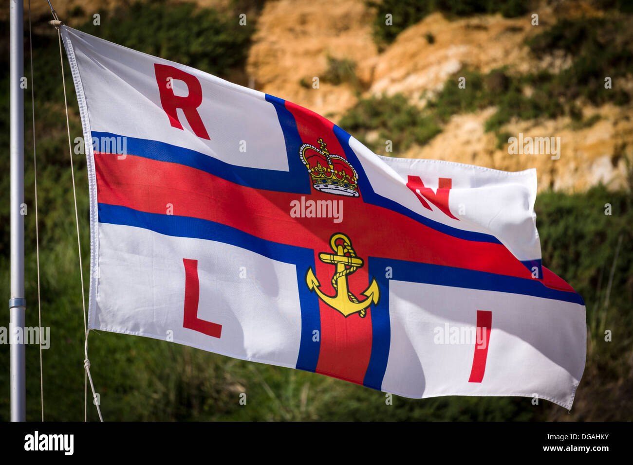Il Royal National scialuppa di salvataggio (RNLI) bandiera volando sopra la spiaggia a Bournemouth durante l'altezza del periodo di ferie in agosto. Foto Stock