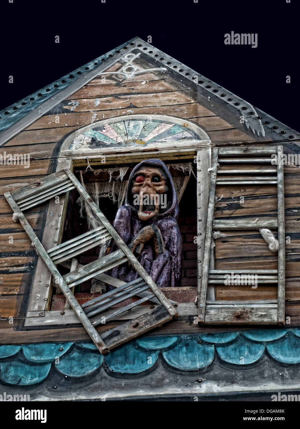 Scary creatura che guarda fuori Haunted House finestra Foto Stock
