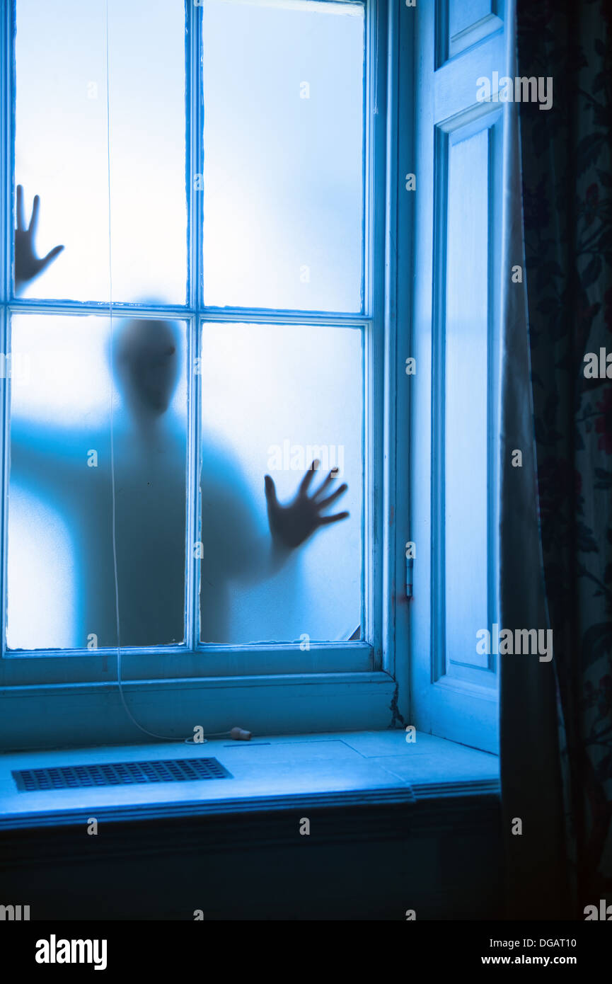 Ladro furto con scasso sinister silhouette di un criminale di commettere un crimine in corrispondenza di una finestra Foto Stock