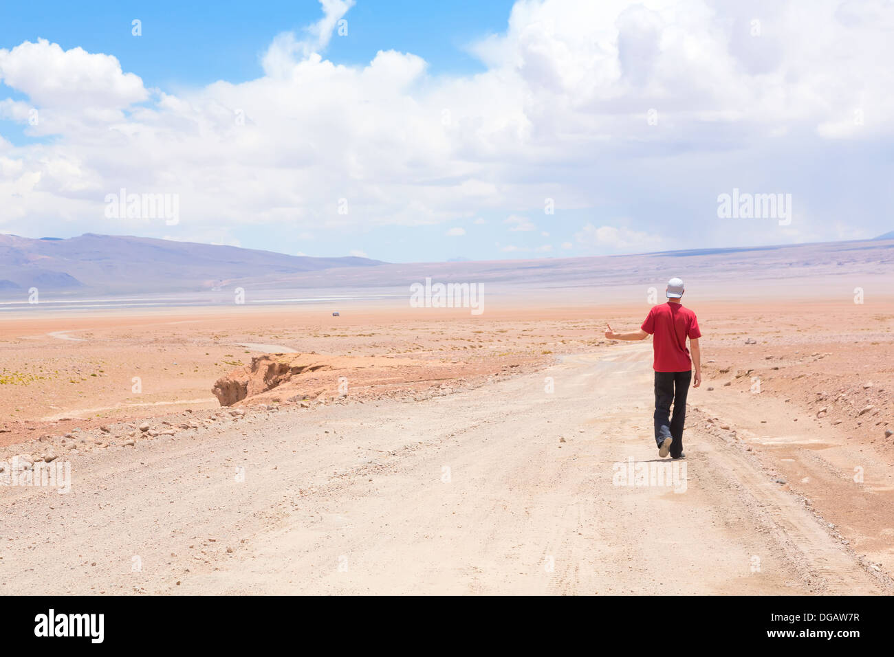 L'uomo autostop l'auto sulla strada deserta, Bolivia Foto Stock