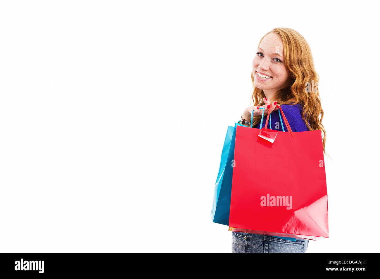 Felice ridendo redhead giovane donna con le borse della spesa su sfondo bianco Foto Stock