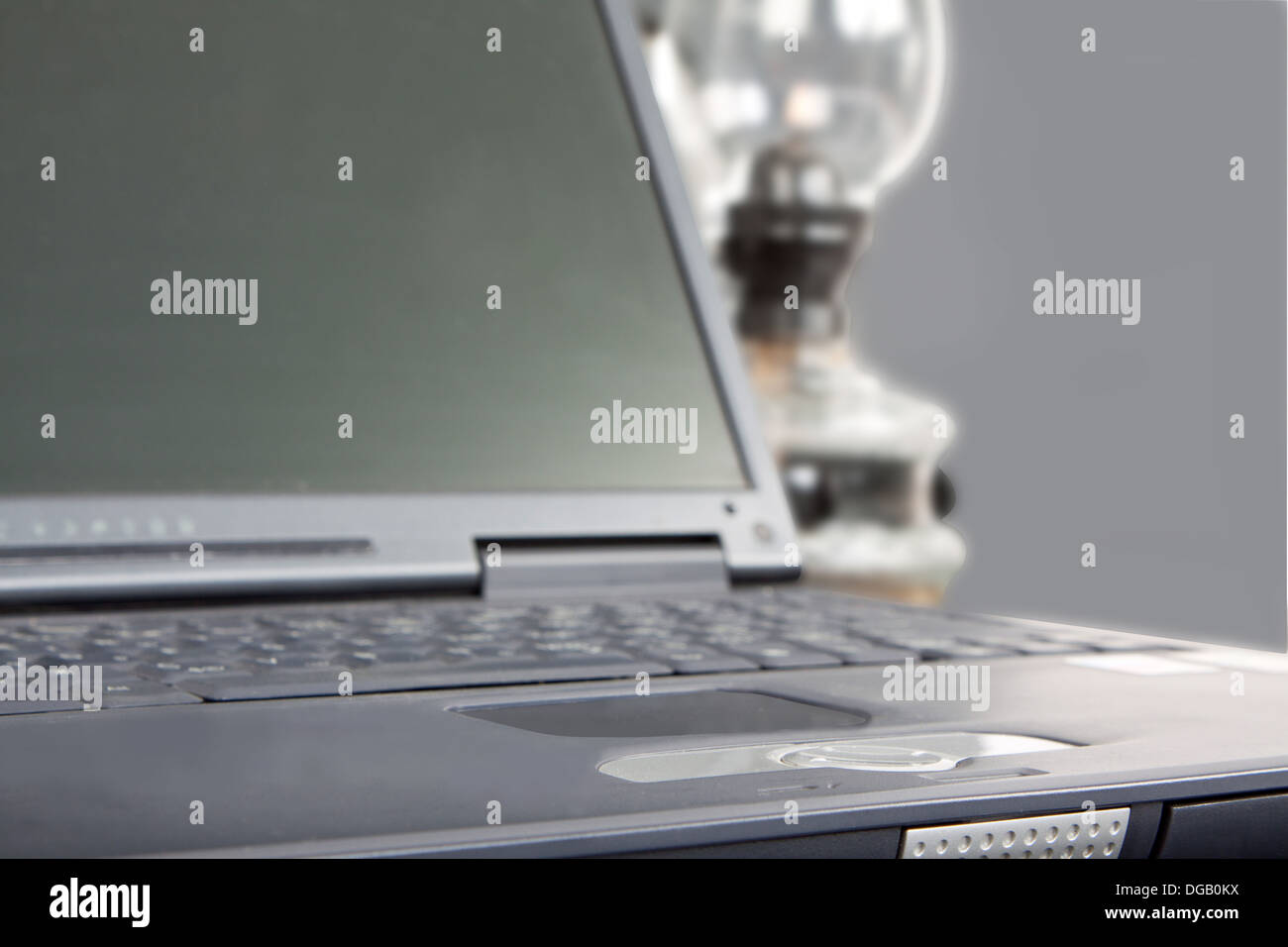 Laptop e la lampada di paraffina in atmosfera grigio Foto Stock