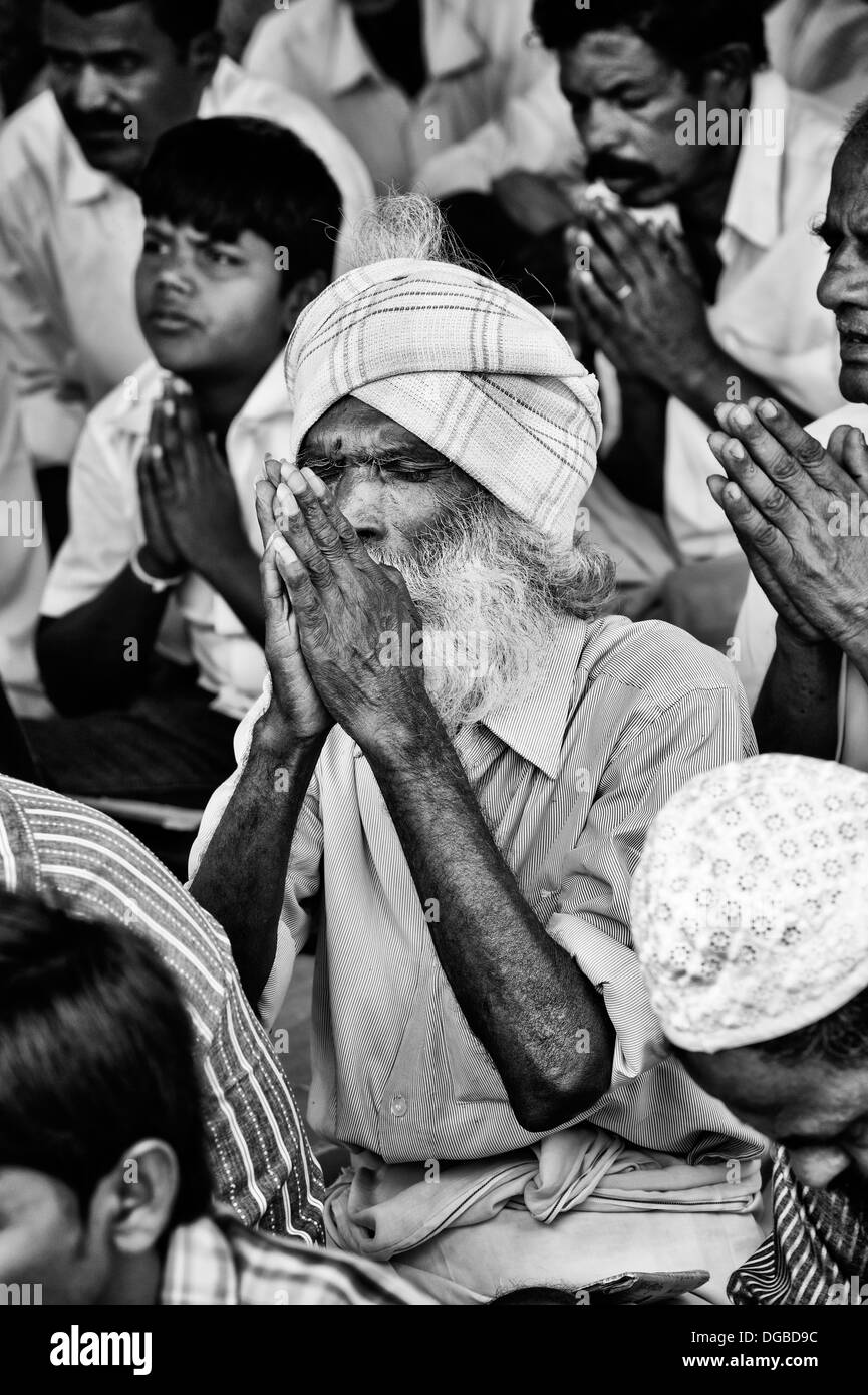 Il vecchio uomo indiano in preghiera in attesa presso Sri Sathya Sai Baba mobile ospedale outreach. Andhra Pradesh, India. Monocromatico Foto Stock