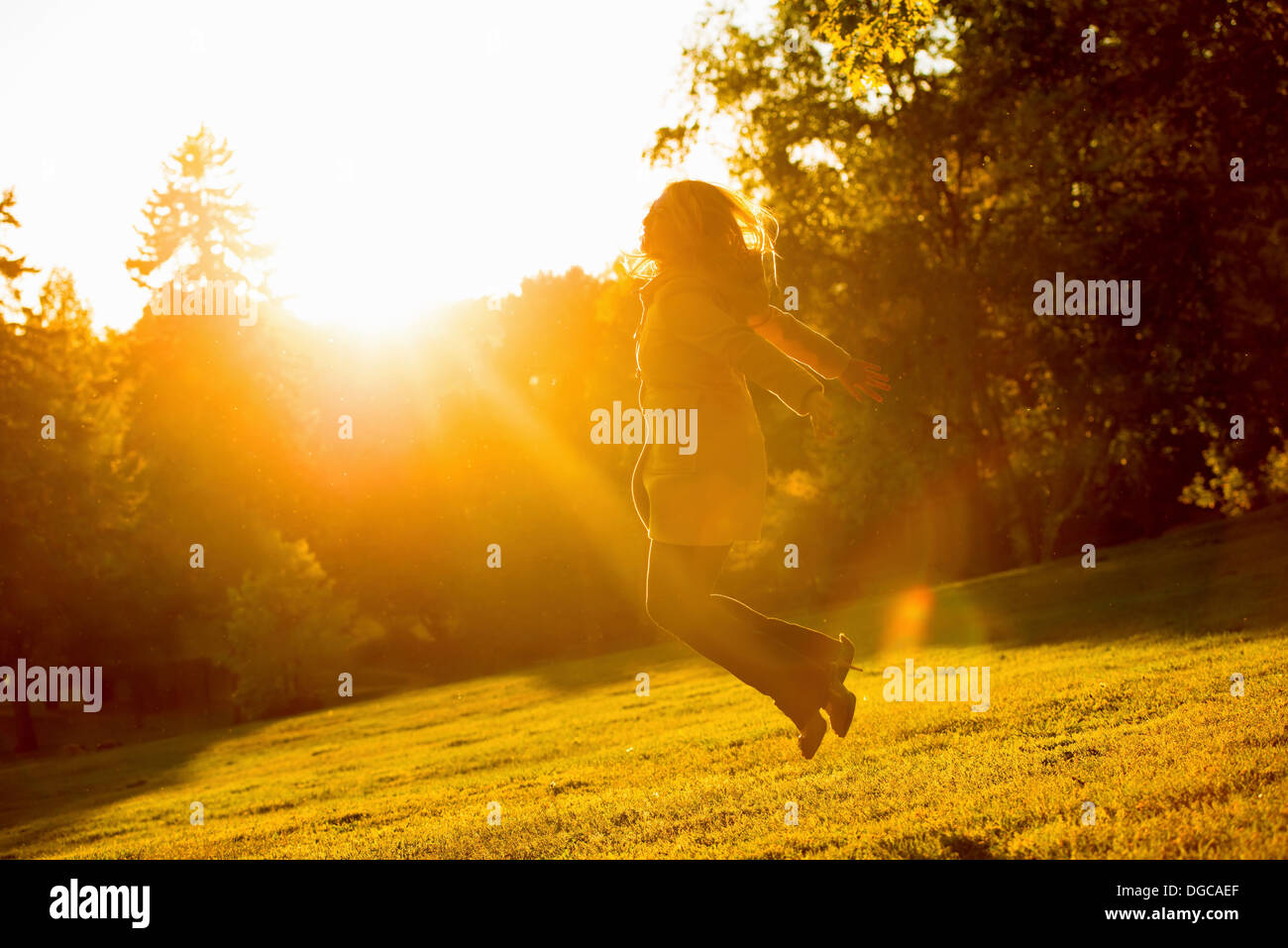 Giovani femmine jumping in posizione di parcheggio Foto Stock