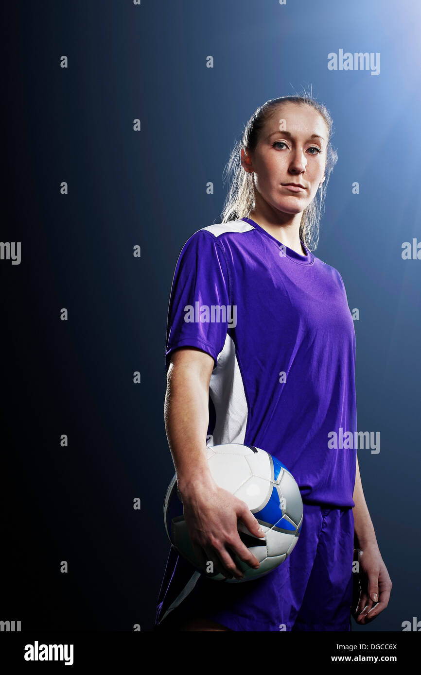 Studio shot di giovani femmine soccer giocatore in possesso palla Foto Stock