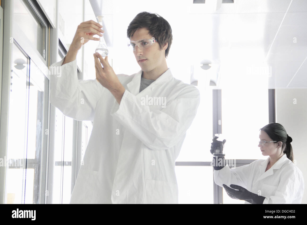 Studenti di chimica guardando i prodotti chimici di laboratorio Foto Stock