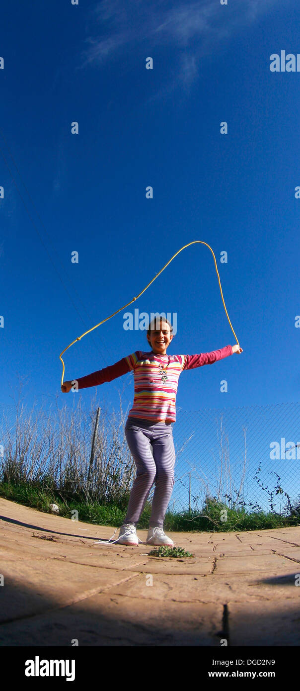 Una ragazzina salta una corda. Foto Stock