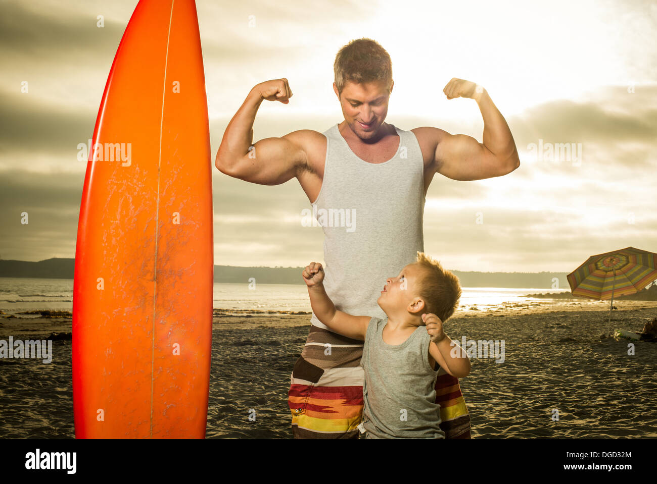 Giovane uomo e figlio di muscoli di flessione sulla spiaggia Foto Stock