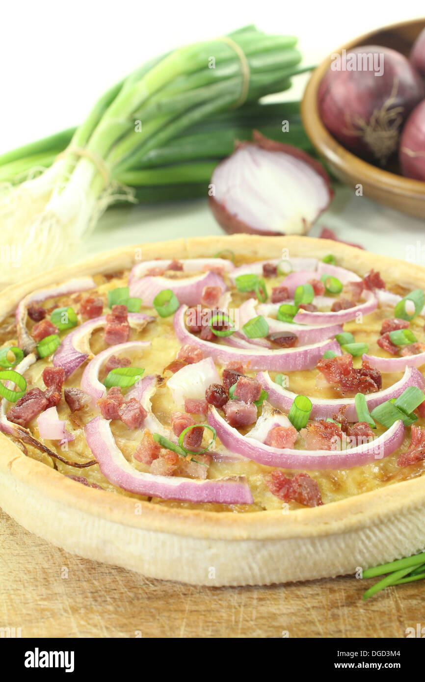 Onion tart con porri e pancetta affumicata su uno sfondo luminoso Foto Stock