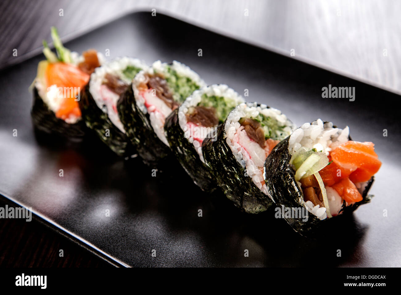 Maki Sushi assortimento rotolo sul piatto nero Foto Stock