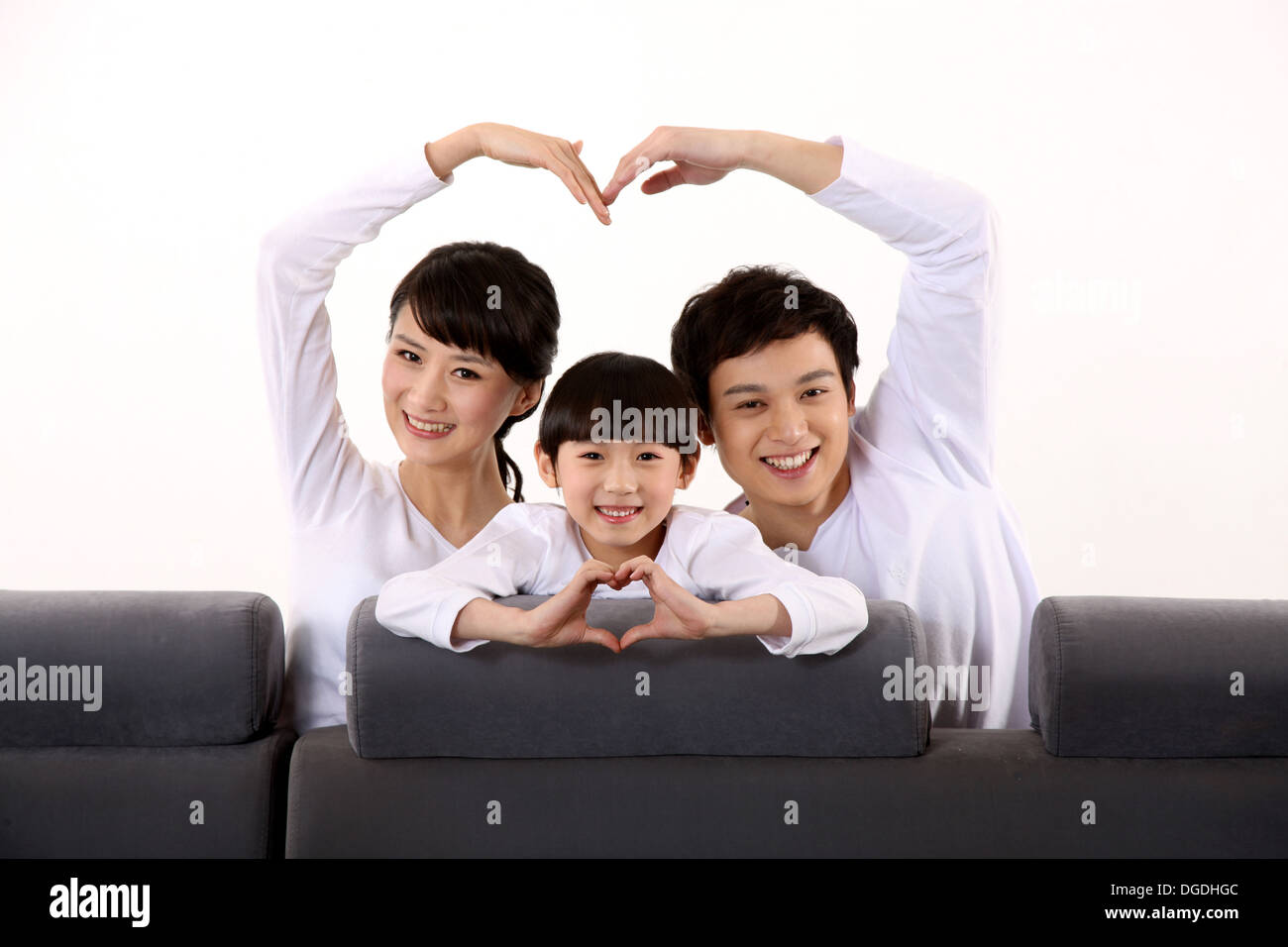Oriente famiglia asiatica con un bambino seduto sul divano, mettendo a forma di cuore Foto Stock