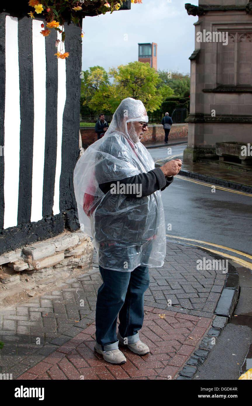 L uomo indossa mac in plastica, Stratford-upon-Avon, Regno Unito Foto Stock