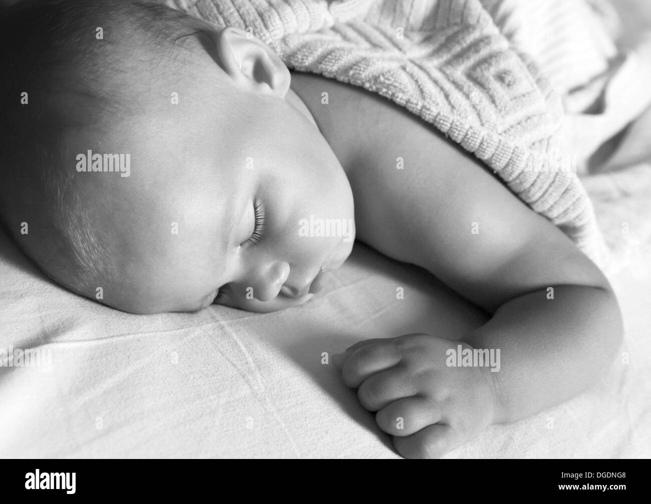 Ritratto in bianco e nero di piccolo bambino dorme nel letto sotto coperta morbida Foto Stock